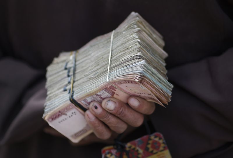 &copy; Reuters. رجل يمسك حزم أوراق نقدية أفغانية في كابول. صورة من أرشيف رويترز