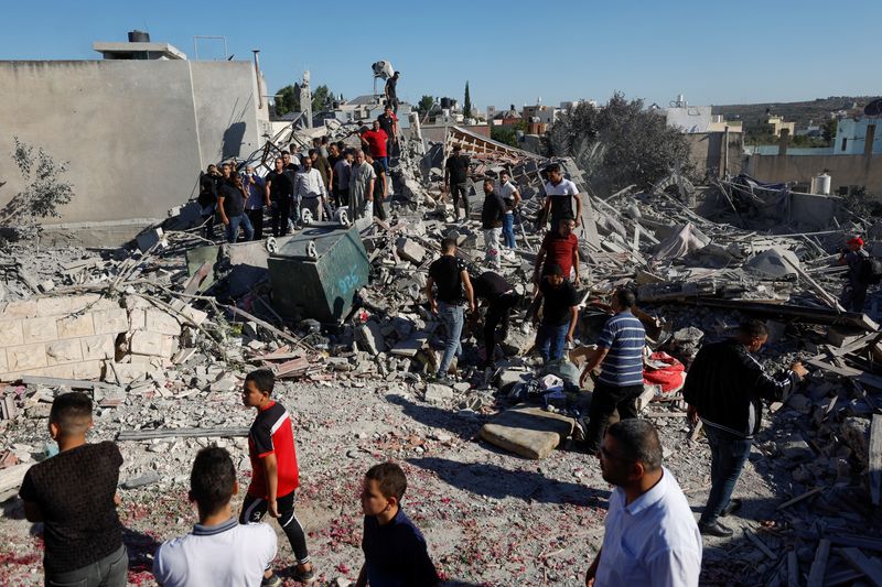 &copy; Reuters. أشخاص يتجمعون حول حطام منزل فجرته القوات الإسرائيلية في قراوة بني حسن بالضفة الغربية يوم الثلاثاء. تصوير: تصوير: محمد تركمان - رويترز.