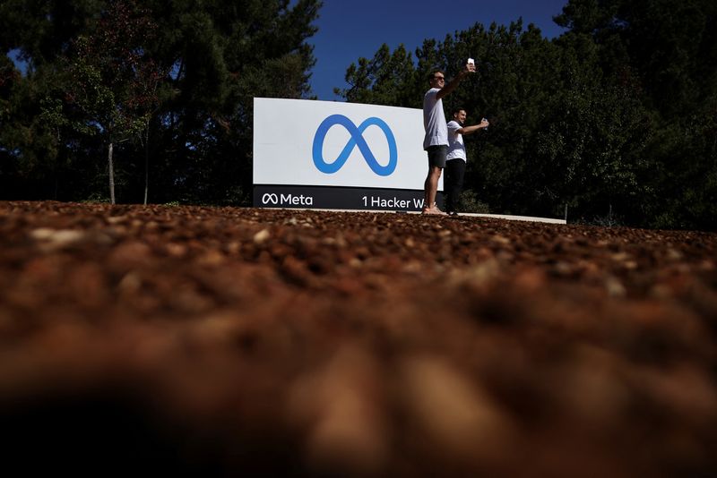 &copy; Reuters. FILE PHOTO: Men take selfies in front of a sign of Meta, the new name for the company formerly known as Facebook, at its headquarters in Menlo Park, California, U.S. October 28, 2021. REUTERS/Carlos Barria GLOBAL BUSINESS WEEK AHEAD