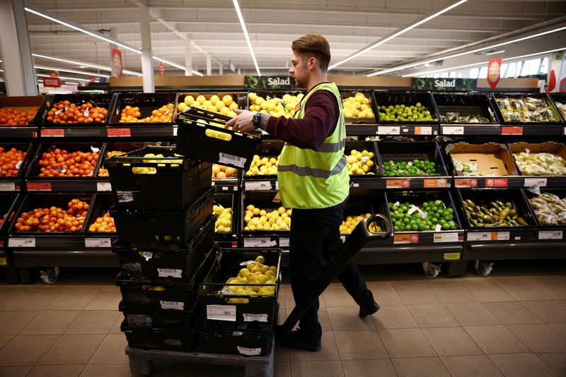 © Reuters. FILE PHOTO: A employee arranges produce inside a Sainsbury’s supermarket in Richmond, west London, Britain, June 27, 2022. REUTERS/Henry Nicholls