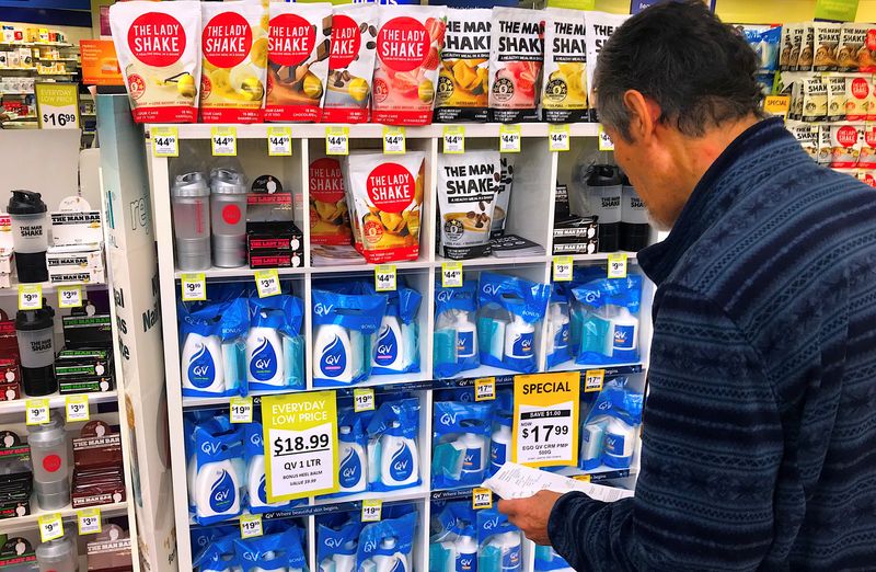 © Reuters. FILE PHOTO: A customer looks at products marked with discounted prices on display at a chemist in a shopping mall in central Sydney, Australia, July 25, 2018.    REUTERS/David Gray