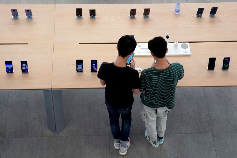 &copy; Reuters. FILE PHOTO: People look at smartphones in Huawei's first global flagship store in Shenzhen, Guangdong province, China October 30, 2019. REUTERS/Aly Song/File Photo