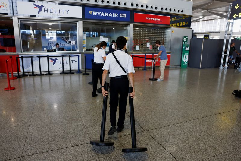 &copy; Reuters. Trabajadores se preparan para delimitar el mostrador de información de Ryanair durante una huelga de tripulantes de cabina, en el aeropuerto de Málaga-Costa del Sol, en Málaga, España, el 1 de julio de 2022. REUTERS/Jon Nazca