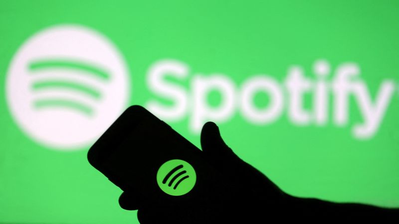 &copy; Reuters. FILE PHOTO: A smartphone is seen in front of a screen projection of the Spotify logo in this picture illustration taken April 1, 2018. REUTERS/Dado Ruvic/Illustration/File Photo 