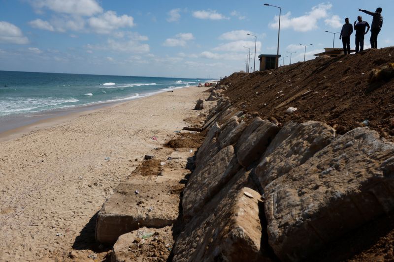 &copy; Reuters. مسؤولون في البلدية يتفقدون الحواجز الخرسانية التي وضعوها مؤخرا على شاطئ بقطاع غزة في صورة التقطت في 24 يوليو تموز 2022. تصوير إبراهيم أبو مصطفى