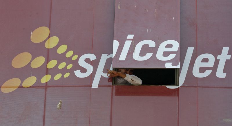 &copy; Reuters. FILE PHOTO: A man looks out through a window with an advertisement of SpiceJet Airline, on a commercial building in the western Indian city of Ahmedabad February 14, 2014. REUTERS/Amit Dave 