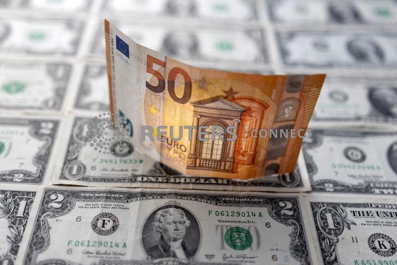&copy; Reuters. Una banconota da 50 euro sopra delle banconote di dollari statunitensi. 14 febbraio 2022. REUTERS/Dado Ruvic/Illustration/File Photo