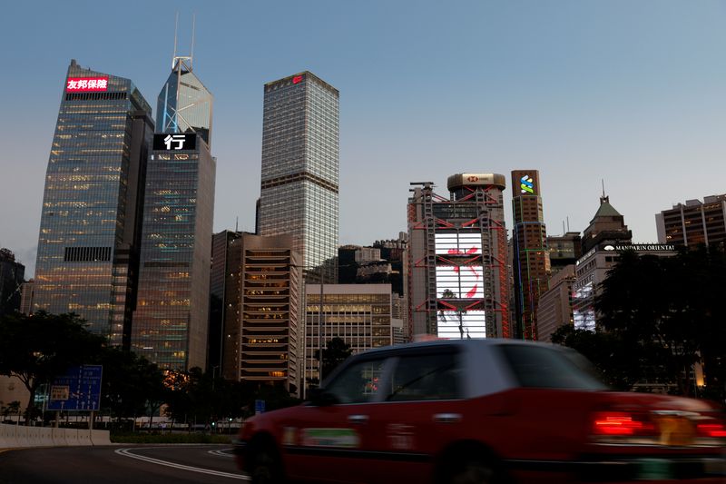 © Reuters. FILE PHOTO: A taxi drives in front of skyscrapers at the central business district, including AIA Central, China Construction Bank (CCB) Tower, Bank of China Tower, Cheung Kong Centre, HSBC and Standard Chartered Bank headquarters, in Hong Kong, China August 17, 2021. REUTERS/Tyrone Siu