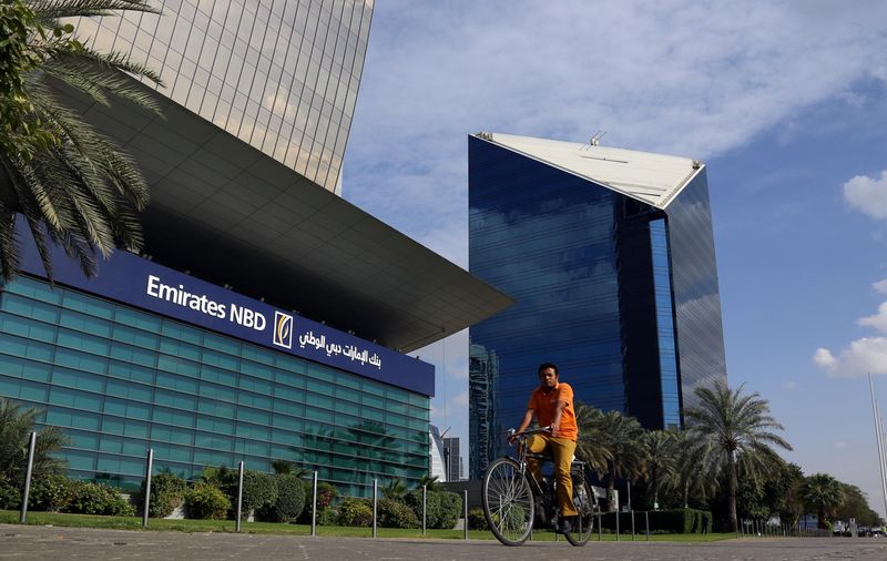 &copy; Reuters. رجل يقود دراجة هوائية يمر بمقر بنك الإمارات دبي الوطني في دبي بصورة من أرشيف رويترز.