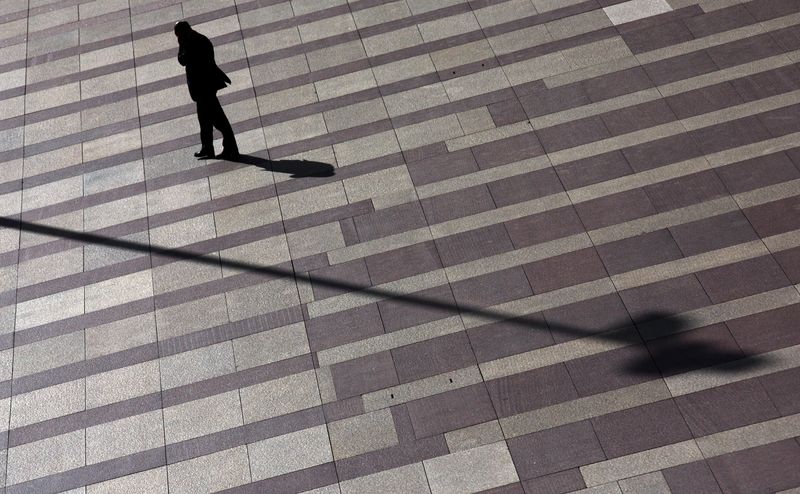 &copy; Reuters. FILE PHOTO: A man talks on mobile phone as he walks on a patterned floor at a yard outside an office building in Madrid's financial district November 17, 2014. REUTERS/Sergio Perez  