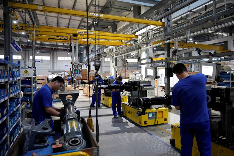 &copy; Reuters. FILE PHOTO: Employees work on the production line of vehicle components during a government-organised media tour to a factory of German engineering group Voith, following the coronavirus disease (COVID-19) outbreak, in Shanghai, China July 21, 2022. REU