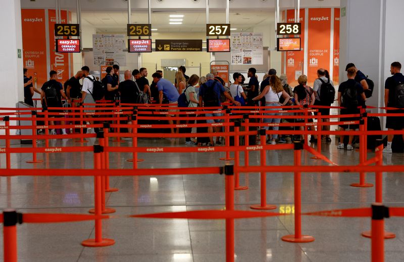 &copy; Reuters. FILE PHOTO: People queue at Easyjet's check-in desks during an Easyjet cabin crew strike, at Malaga-Costa del Sol Airport, in Malaga, Spain, July 1, 2022. REUTERS/Jon Nazca