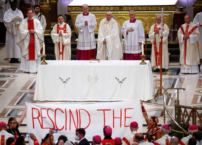 &copy; Reuters. Manifestantes seguram faixa de protesto enquanto papa Francisco celebra missa na catedral de Sainte-Anne-de-Beaupre, em Quebec, no Canadá
28/07/2022 REUTERS/Guglielmo Mangiapane