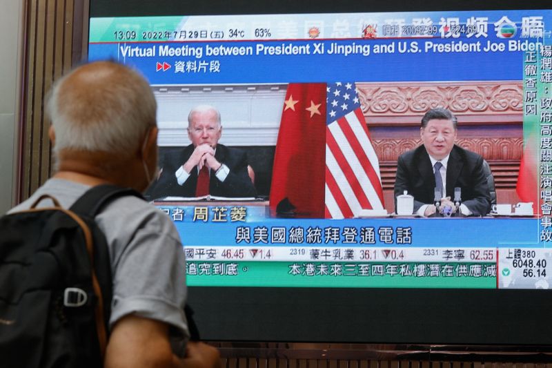 © Reuters. A screen displays images of Chinese President Xi Jinping and U.S. President Joe Biden, while broadcasting news about their recent call at a shopping mall in Hong Kong, China, July 29, 2022. REUTERS/Tyrone Siu