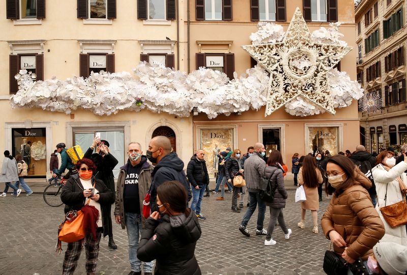 &copy; Reuters. People wear protective masks as they walk on Piazza di Spagna, as the city makes masks mandatory outdoors in busy areas amid a rise in coronavirus cases, ahead of Christmas, in Rome, Italy, December 4, 2021. REUTERS/Remo Casilli