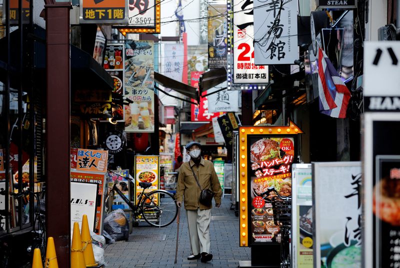 &copy; Reuters. FILE PHOTO: A man wearing a protective mask, amid the coronavirus disease (COVID-19) outbreak, makes his way at a restaurant district in Tokyo, Japan, December 1, 2021. REUTERS/Kim Kyung-Hoon/File Photo