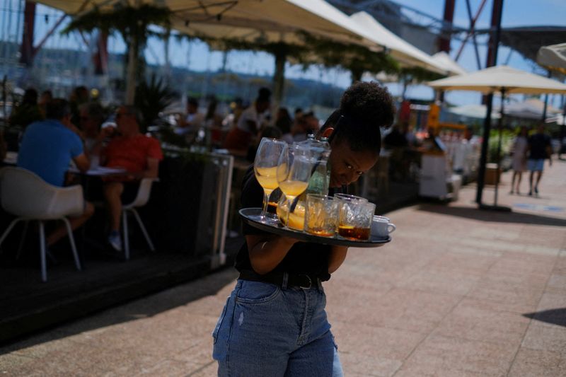 &copy; Reuters. FILE PHOTO: A waitress removes drinks from a table in a restaurant in Lisbon, Portugal, June 6, 2022. Picture taken June 6, 2022. REUTERS/Pedro Nunes/File Photo