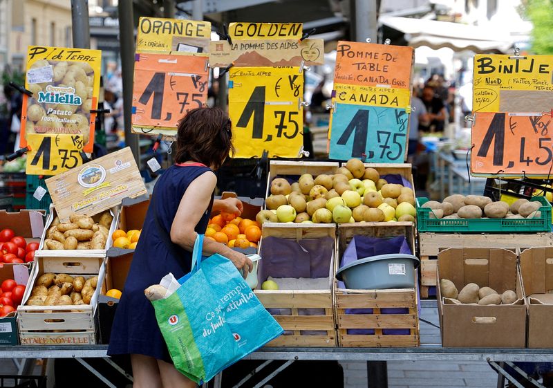 © Reuters. FILE PHOTO: Price tags are seen as a woman shops at a local market in Nice, France, June 7, 2022. REUTERS/Eric Gaillard