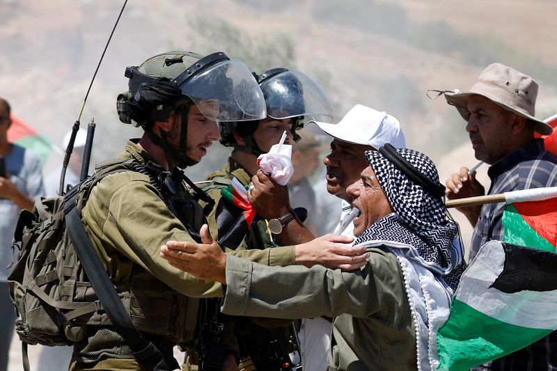 &copy; Reuters. Manifestantes palestinos discuten con miembros de las fuerzas armadas de Israel durante una protesta contra los asentamientos de colonos israelíes en la aldea de Al Mughayyir, en la Cisjordania ocupada por Israael, el 29 de julio de 2022. REUTERS/Mohamad