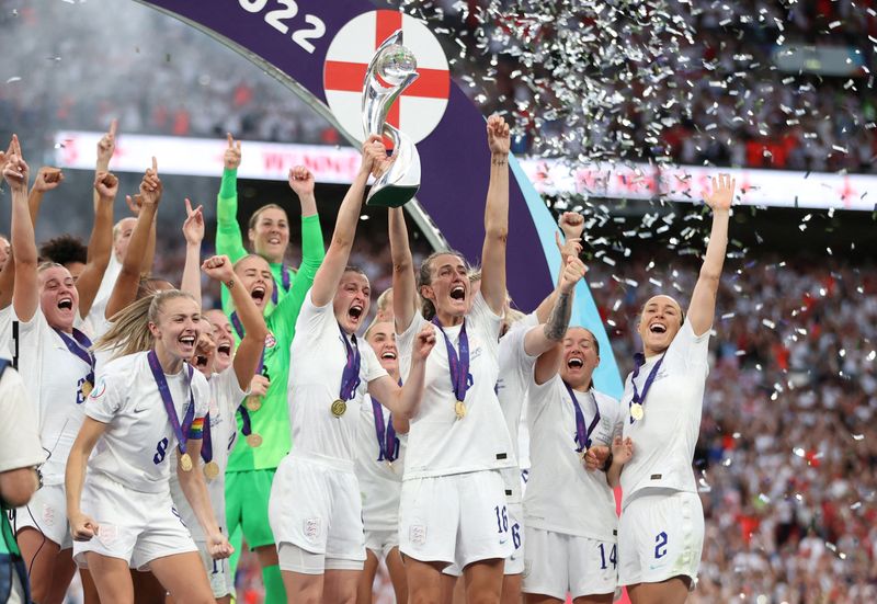&copy; Reuters. Soccer Football - Women's Euro 2022 - Final - England v Germany - Wembley Stadium, London, Britain - July 31, 2022 England's Ellen White and Jill Scott lift the trophy as they celebrate with teammates after winning Women's Euro 2022 REUTERS/Molly Darlingt
