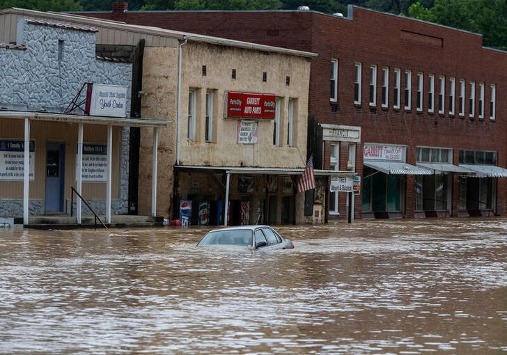 &copy; Reuters. 米南部ケンタッキー州のビシア知事は３１日、州東部を襲った豪雨による洪水で子ども４人を含む少なくとも２８人が死亡したと発表した。写真は、同州内の洪水で自動車が浸水している様