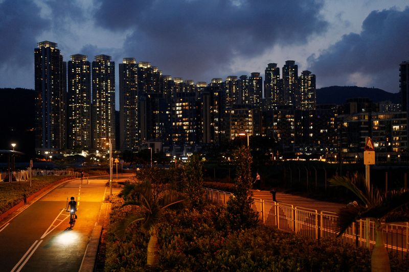 &copy; Reuters. A man rides a bicycle past residential buildings, ahead of the 25th anniversary of Hong Kong's handover to China from Britain, in Hong Kong, China May 21, 2022. Picture taken May 21, 2022. REUTERS/Tyrone Siu