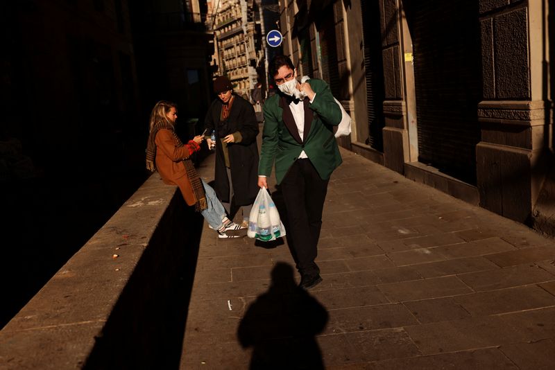 &copy; Reuters. A waiter wearing a face mask carries a bag with milk as he walks to the restaurant where he works, amid the coronavirus disease (COVID-19) pandemic in Barcelona, Spain February 1, 2022. REUTERS/Nacho Doce