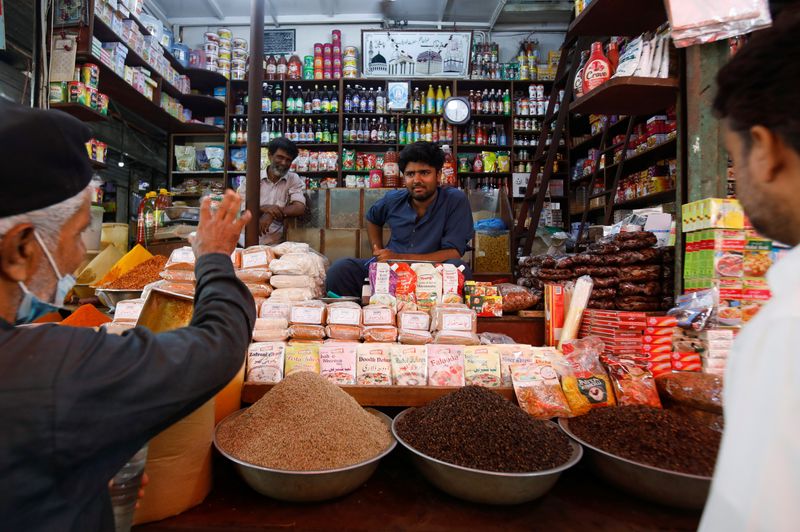 &copy; Reuters. FILE PHOTO: A shopkeeper listens to a customer as he sells groceries at a shop in a market in Karachi, Pakistan June 10, 2022. REUTERS/Akhtar Soomro