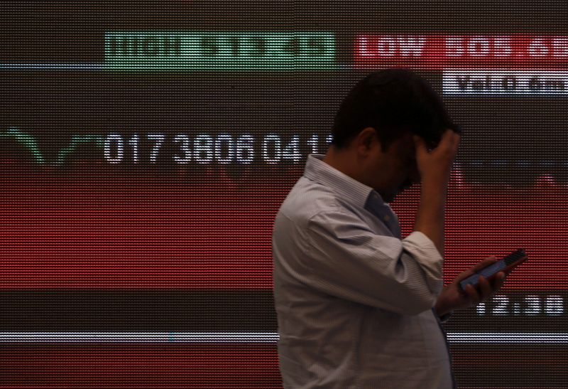 © Reuters. FILE PHOTO: A man stands in front of a screen displaying news of markets updates inside the Bombay Stock Exchange (BSE) building in Mumbai, India, January, 3, 2020. REUTERS/Francis Mascarenhas/File Photo