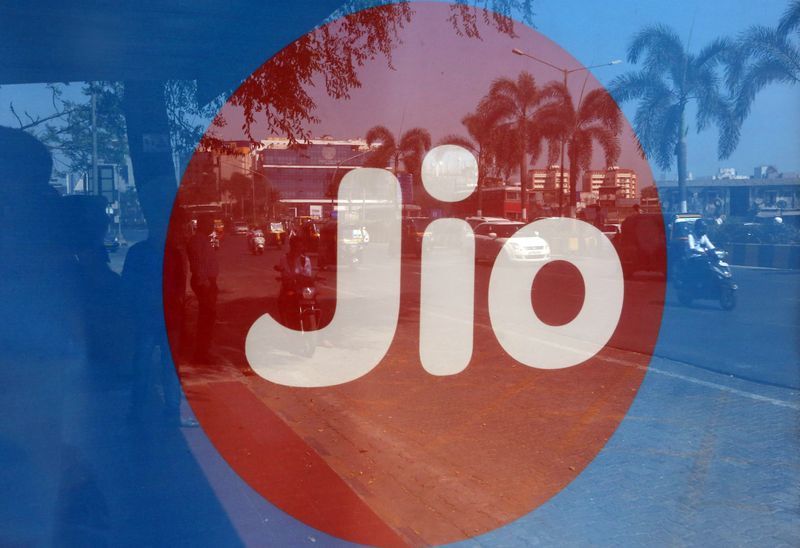 © Reuters. FILE PHOTO: Commuters are reflected on an advertisement of Reliance Industries' Jio telecoms unit, at a bus stop in Mumbai, India, February 21, 2017. REUTERS/Shailesh Andrade