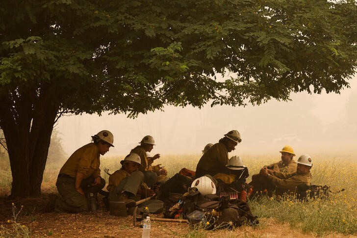 &copy; Reuters. Bomberos locales descansan a la sombra de un árbol durante su combate del incendio McKinney cerca de Yreka, California, EEUU. 31 julio 2022. REUTERS/Fred Greaves