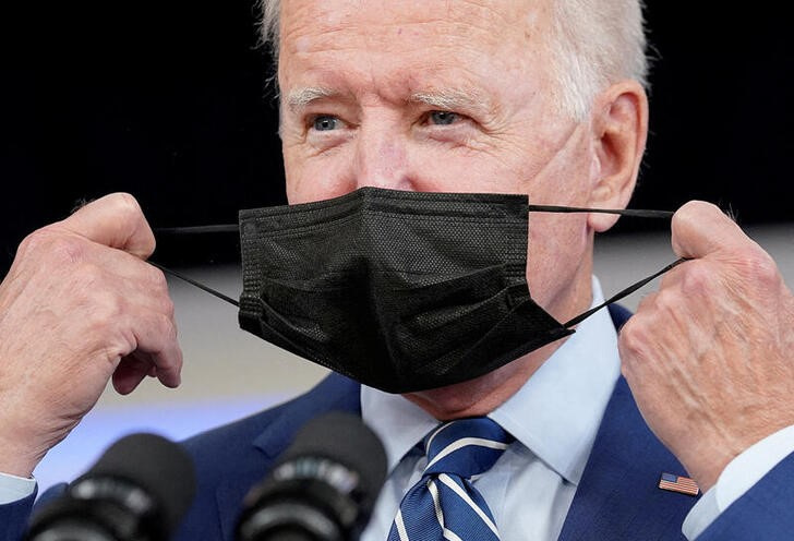 &copy; Reuters. Imagen de archivo del presidente de EEUU, Joe Biden, sacándose la mascarilla antes de recibir la vacuna de refuerzo en la Casa Blanca, Washington, EEUU. 27 septiembre 2021. REUTERS/Kevin Lamarque