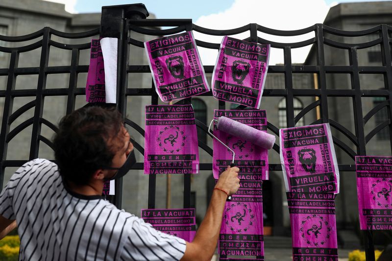 &copy; Reuters. Un activista pega carteles en una valla durante una protesta para pedir una respuesta más contundente del gobierno a la crisis de la viruela del mono, frente al edificio de la Secretaría de Salud, en Ciudad de México, México. 26 de julio, 2022. REUTER