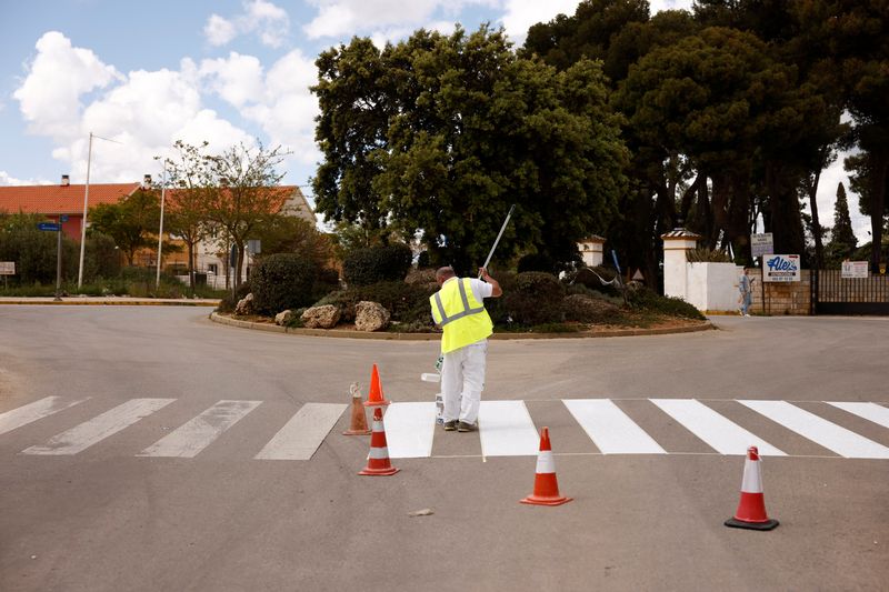 &copy; Reuters. A worker paints a crosswalk in Ronda, southern Spain, April 27, 2022. REUTERS/Jon Nazca