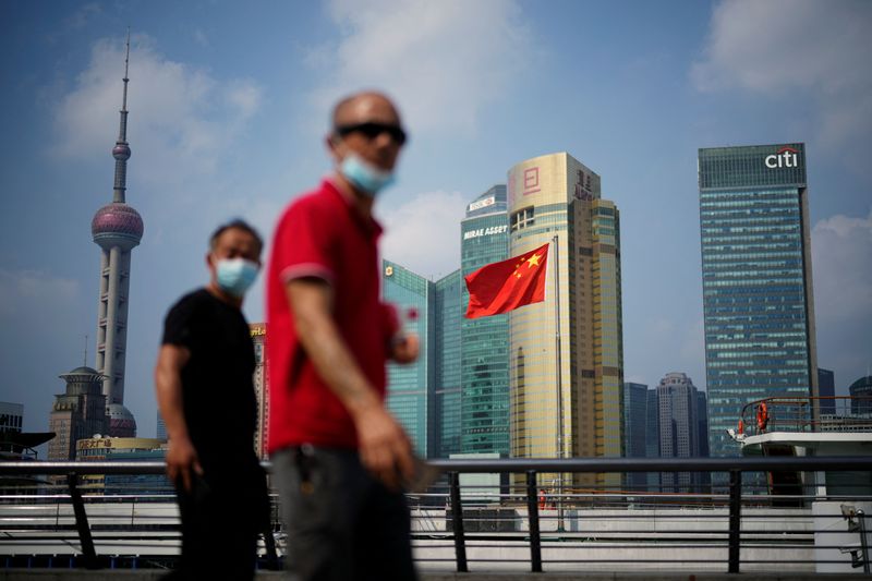 &copy; Reuters. Pedestres passam por bandeira da China na cidade de Xangai
02/08/2022
REUTERS/Aly Song