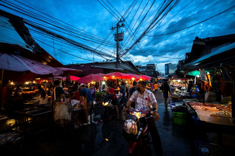 &copy; Reuters. People wearing face masks shop inside a market amid the spread of the coronavirus disease (COVID-19) in Bangkok, Thailand, November 16, 2021. REUTERS/Athit Perawongmetha