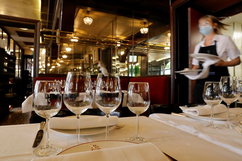 &copy; Reuters. A waiter serves dishes in a dining room at Au Petit Riche restaurant in Paris as cafes, bars and restaurants reopen indoor dining rooms with a fitted gauge and health protocol after closing down for months amid the coronavirus disease (COVID-19) outbreak 