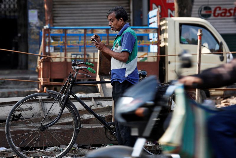 &copy; Reuters. FILE PHOTO: A man checks his mobile phone as he stands on a busy road in Kolkata, India January 6, 2017. REUTERS/Rupak De Chowdhuri