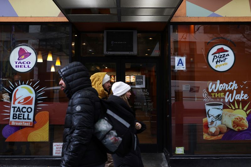 © Reuters. FILE PHOTO: People walk by a Taco Bell and Pizza Hut, subsidiaries of Yum! Brands, Inc. in Manhattan, New York City, U.S., February 7, 2022. REUTERS/Andrew Kelly