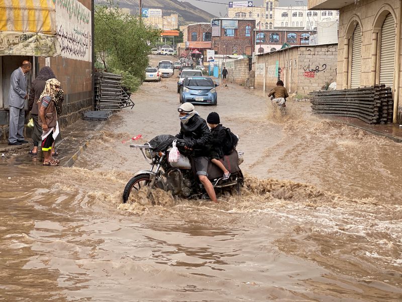&copy; Reuters. شخص يقود دراجة نارية عبر شارع تغمره مياه الفيضانات الناجمة عن الأمطار الغزيرة بالعاصمة اليمنية صنعاء في الأول من أغسطس آب 2022. تصوير: خالد عب