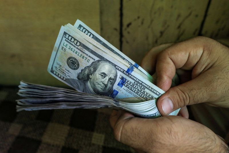 &copy; Reuters. FILE PHOTO: A trader counts U.S. dollar banknotes at a currency exchange booth in Peshawar, Pakistan September 15, 2021. REUTERS/Fayaz Aziz/File Photo