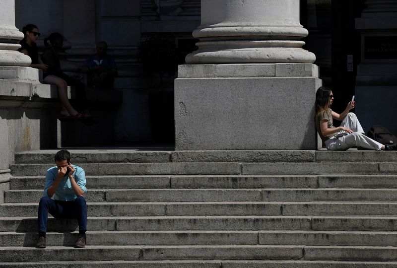 © Reuters. FILE PHOTO: People sit outside near the Bank of England during the hot weather in the City of London financial district, London, Britain, July 19, 2022. REUTERS/Toby Melville