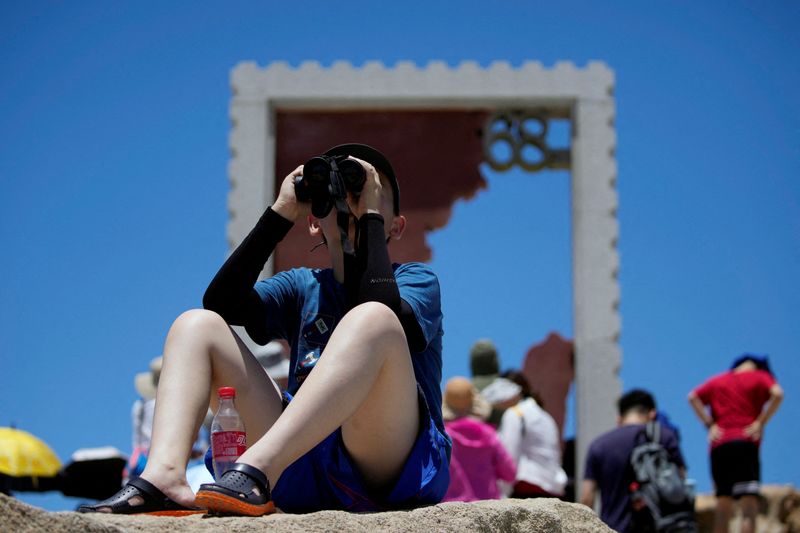 &copy; Reuters. Un niño sostiene unos prismáticos en el punto panorámico de 68 millas náuticas, uno de los puntos más cercanos de China continental a la isla de Taiwán, en la isla Pingtan, provincia de Fujian, China. 5 de agosto de 2022. REUTERS/Aly Song