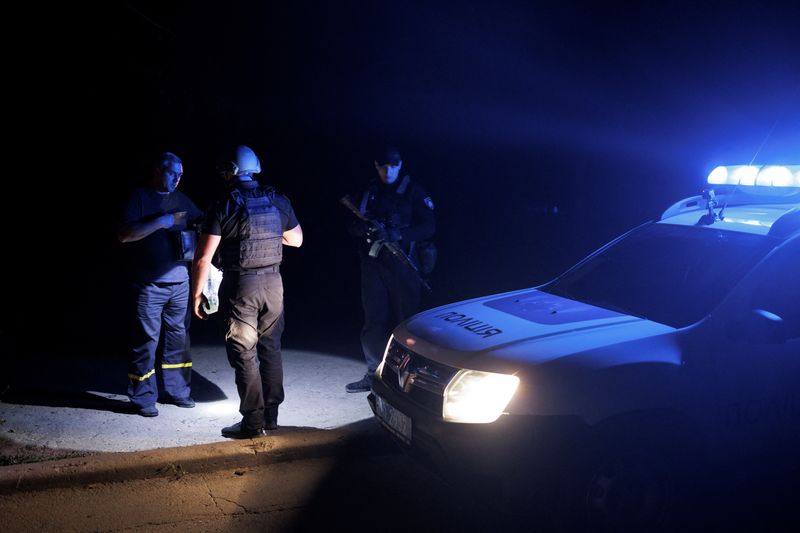 Ukraine police patrol dark night time streets, seeking curfew violators