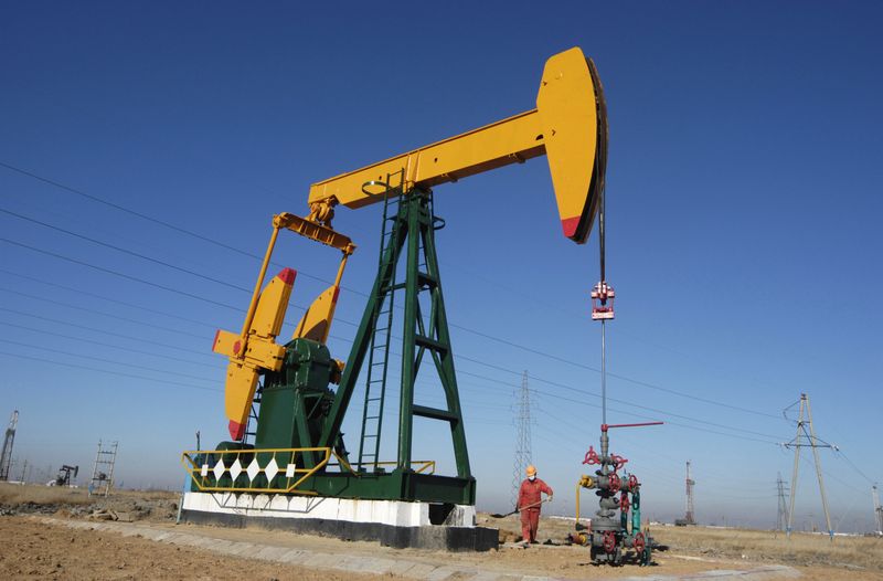 © Reuters. FILE PHOTO - A oil field worker works at a pump jack in PetroChina's Daqing oil field in China's northeastern Heilongjiang province November 5, 2007. REUTERS/Stringer (CHINA) 