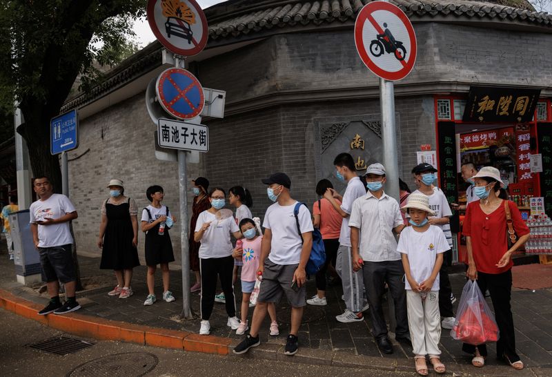 &copy; Reuters. أشخاص يضعون كمامات يقفون في أحد شوارع بكين في الثالث من أغسطس آب 2022. تصوير: توماس بيتر - رويترز