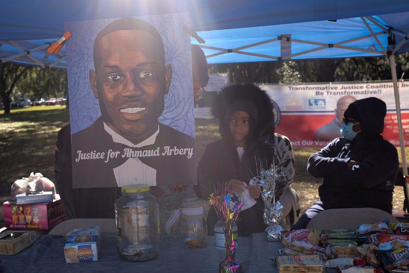 &copy; Reuters. FILE PHOTO: A poster depicting Ahmaud Arbery is seen outside the Glynn County Courthouse while Greg McMichael, his son Travis McMichael and William "Roddie" Bryan are tried over the killing of Ahmaud Arbery, in Brunswick, Georgia, U.S., November 23, 2021.