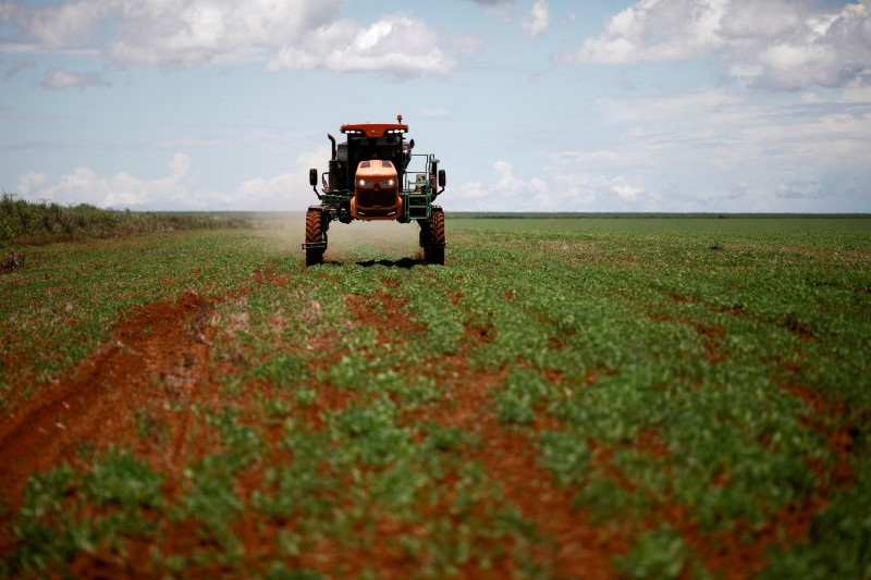 © Reuters. FOTO DE ARQUIVO: Um agricultor dirige um trator espalhando fertilizante em um campo de soja, perto de Brasília, Brasil 15 de fevereiro de 2022.REUTERS/Adriano Machado/Foto de arquivo
