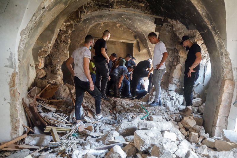 &copy; Reuters. Palestinos inspeccionan un edificio dañado durante los enfrentamientos entre militantes palestinos y fuerzas israelíes en una redada, en Naplusa, en la Cisjordania ocupada por Israel. 9 de agosto de 2022. REUTERS/Raneen Sawafta