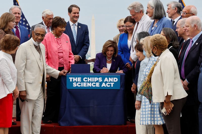 &copy; Reuters. Nancy Pelosi (au centre) et des membres du Congrès lors de la signature du CHIPS And Science Act 2022. Un vaste plan de soutien à l'industrie des semi-conducteurs aux Etats-Unis, visant à rendre le pays plus compétitif par rapport à la Chine, va êtr